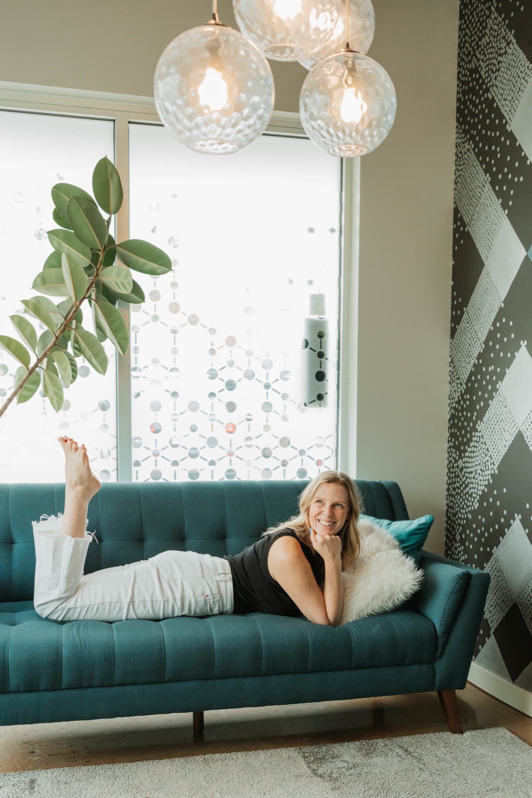 Heather Clift laughing on the couch at Samana Float Center